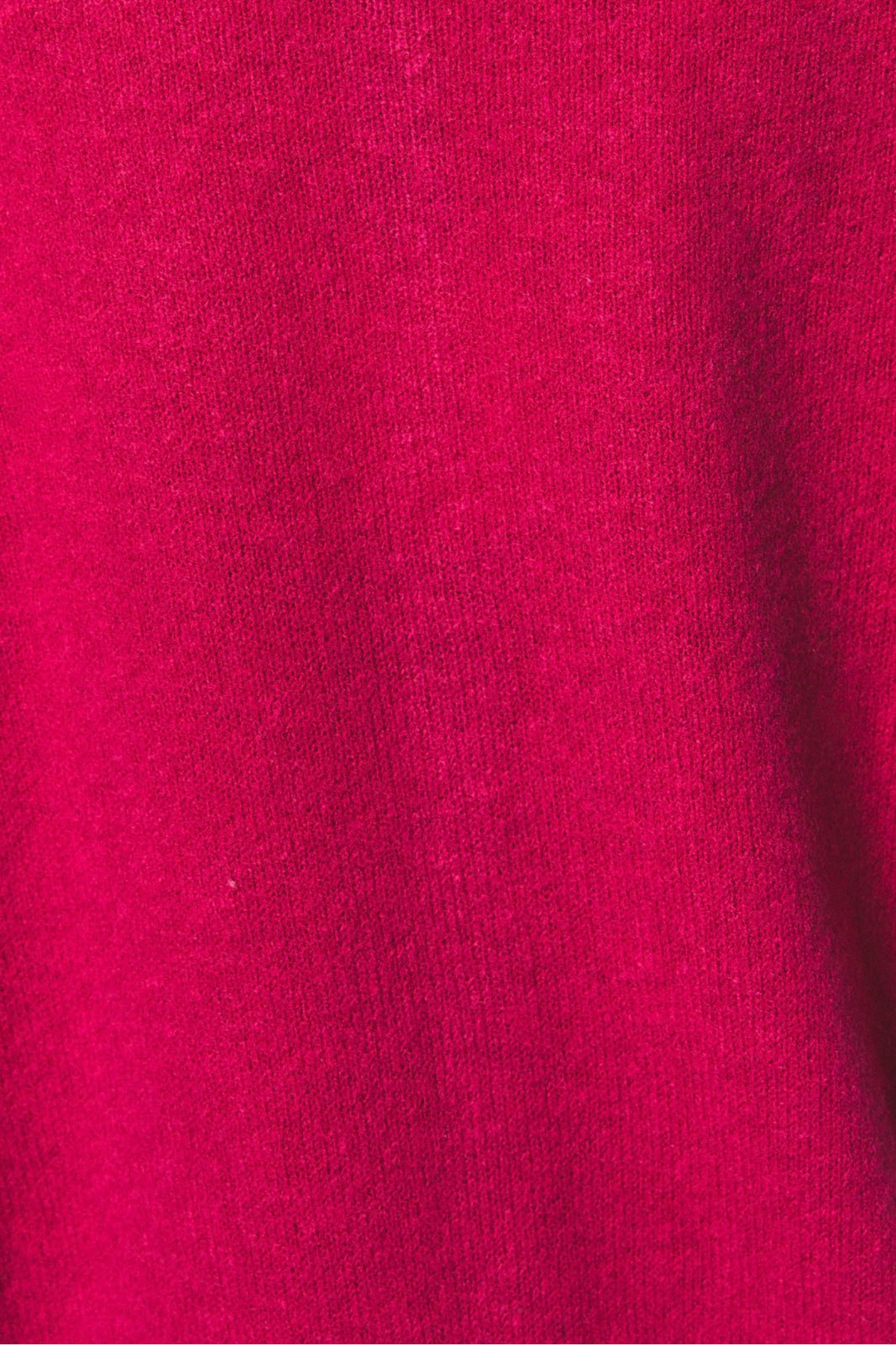 A close-up of bright pink knit fabric with soft folds and a smooth texture.