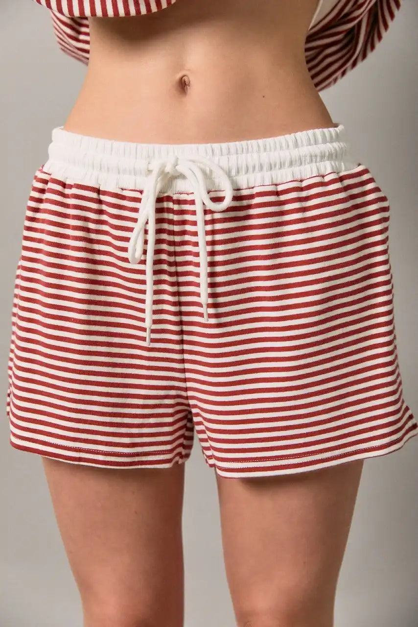 Red and white striped lounge shorts with a white elastic waistband and drawstring, shown on a model from the waist to mid-thigh.