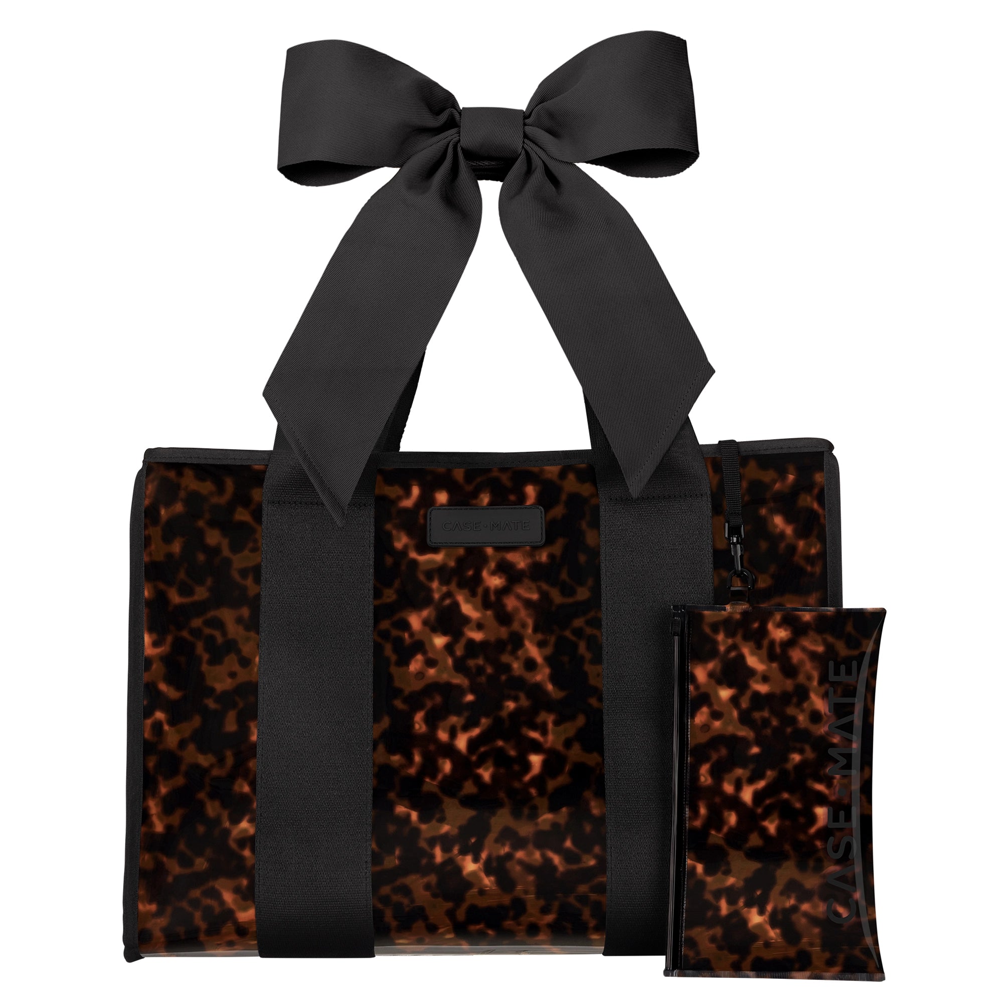 A structured tote bag with a glossy tortoiseshell pattern in brown and black, featuring a large matching black satin bow on the handle and a small matching zip pouch placed in front. The bag is photographed on a clean white background.