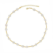 A delicate gold chain necklace featuring irregular white baroque pearls spaced along the chain, displayed on a clean white background.