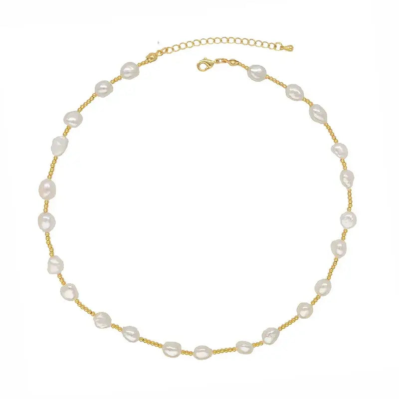 A delicate gold chain necklace featuring irregular white baroque pearls spaced along the chain, displayed on a clean white background.