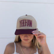 Person wearing a cap with 'Yeehaw' text against a white background