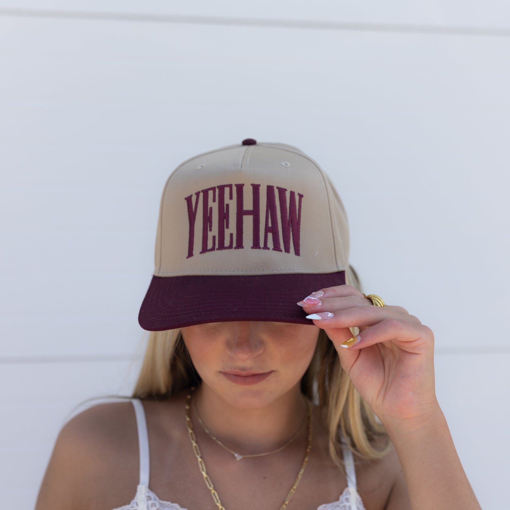 Person wearing a cap with 'Yeehaw' text against a white background