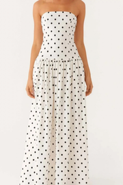 A strapless white maxi dress with a black polka dot pattern, shown on a model against a plain white background.