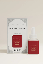 A bottle of k. hall designs Holiday Spice fragrance refill next to its white and red packaging box, set against a solid light beige background.