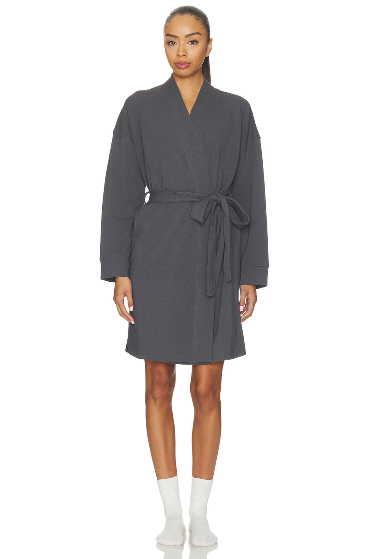 A woman modeling a dark gray wrap robe with a tie belt, paired with white socks, against a plain white background.