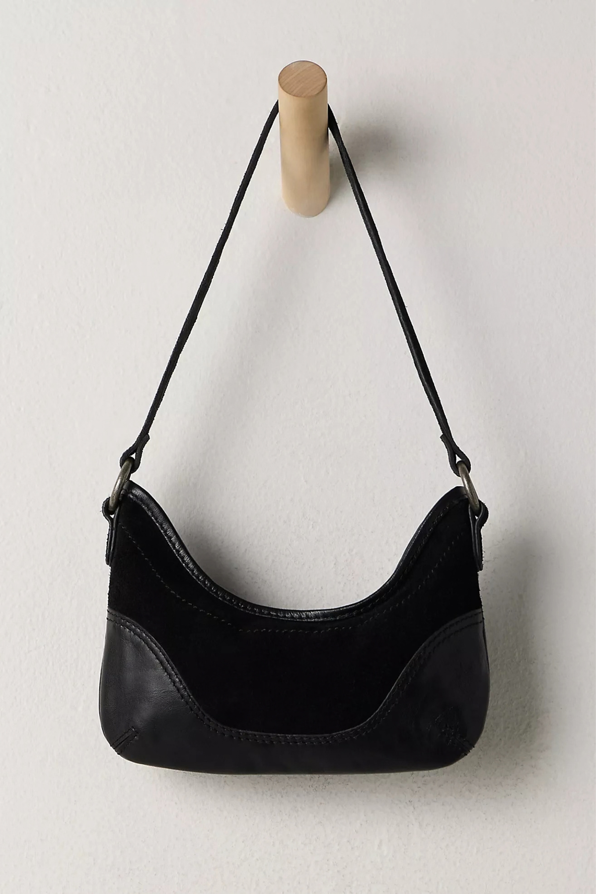 Black handbag with a strap on a light gray background