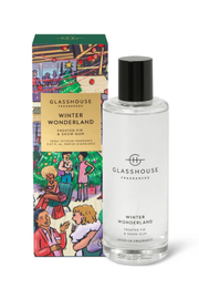 A clear glass bottle of Winter Wonderland by Glasshouse Fragrances with a black cap, standing next to its illustrated green and gold retail box.
