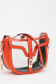 A clear plastic crescent-shaped shoulder bag with bright orange faux-leather trim, a gold-tone buckle, and a gold chain strap, shown on a white background.