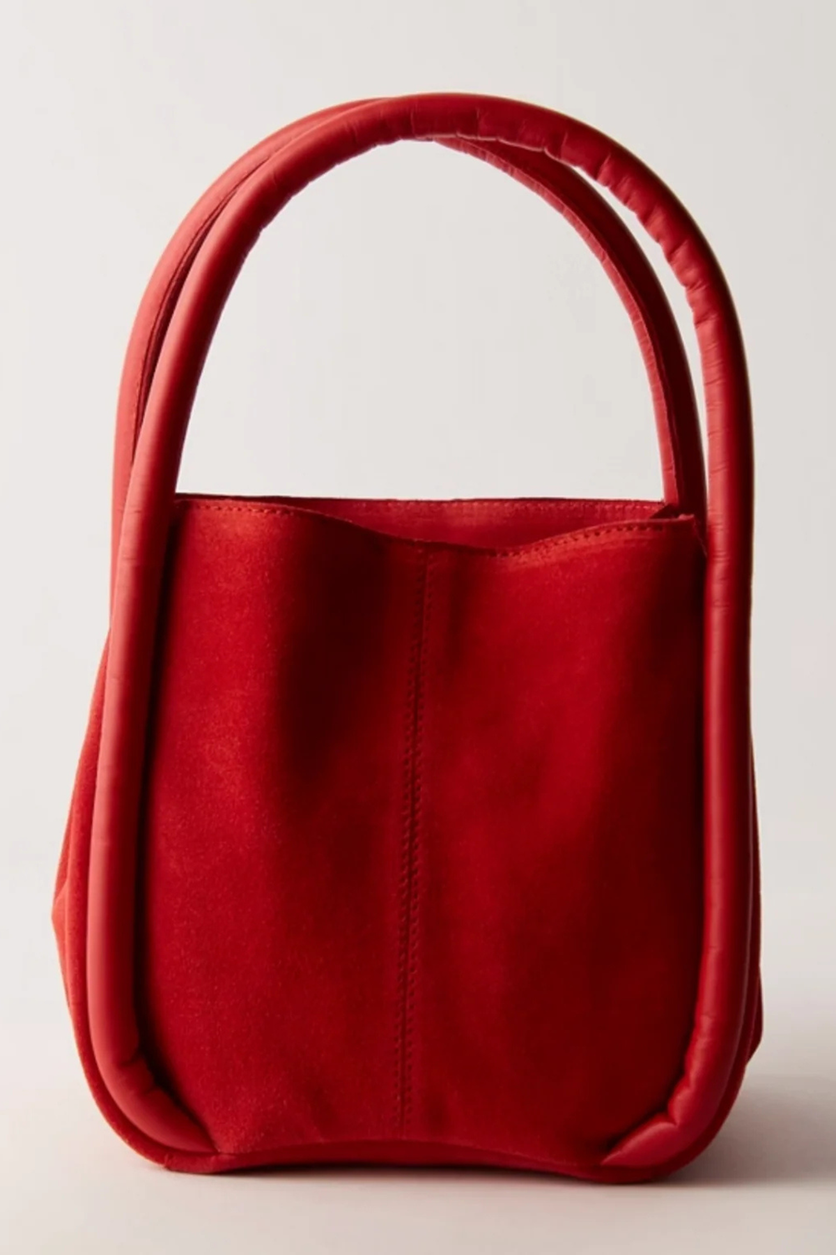 A vibrant red leather handbag with a structured, rounded silhouette and a single integrated top handle, photographed against a clean, light off-white background.