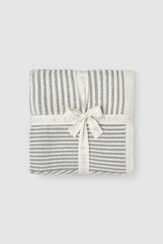 A folded baby blanket with vertical gray and off-white stripes, wrapped in a matching ribbon tied into a bow, on a light gray background.