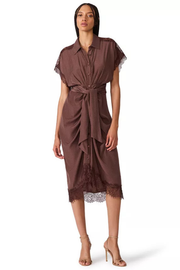 A woman modeling a brown short-sleeve midi shirt dress with lace trim and a self-tie waist, photographed against a plain white studio background.