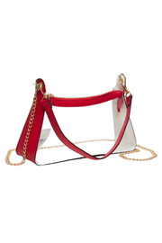 A clear plastic shoulder bag with a red leather top trim, red leather side panels, a red shoulder strap, and a gold chain strap, shown on a plain white background.