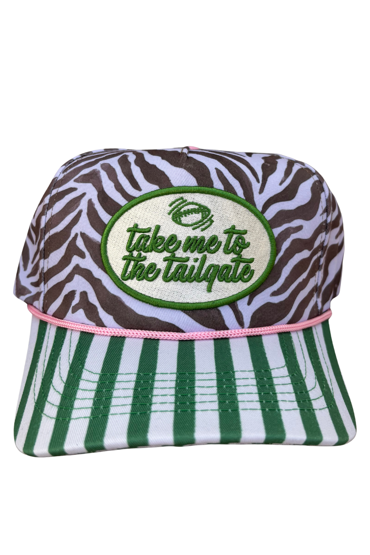 A trucker-style baseball cap featuring a brown and white zebra print crown with a green embroidered oval patch that reads 'take me to the tailgate' with a football graphic. The brim has green and white vertical stripes, a pink stitched edge, and a green embroidered stripe detail on the front.