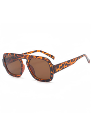 Square aviator-style sunglasses with a bold orange and black leopard print acetate frame and brown tinted lenses, shown on a plain white background.