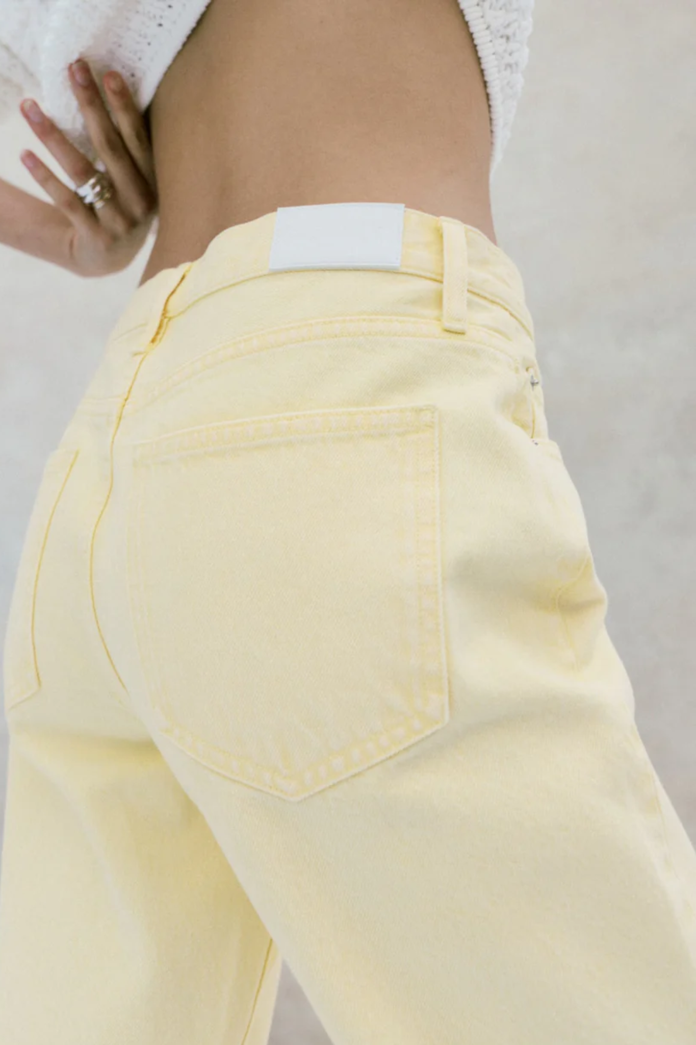 Yellow jeans with a white label on a plain background
