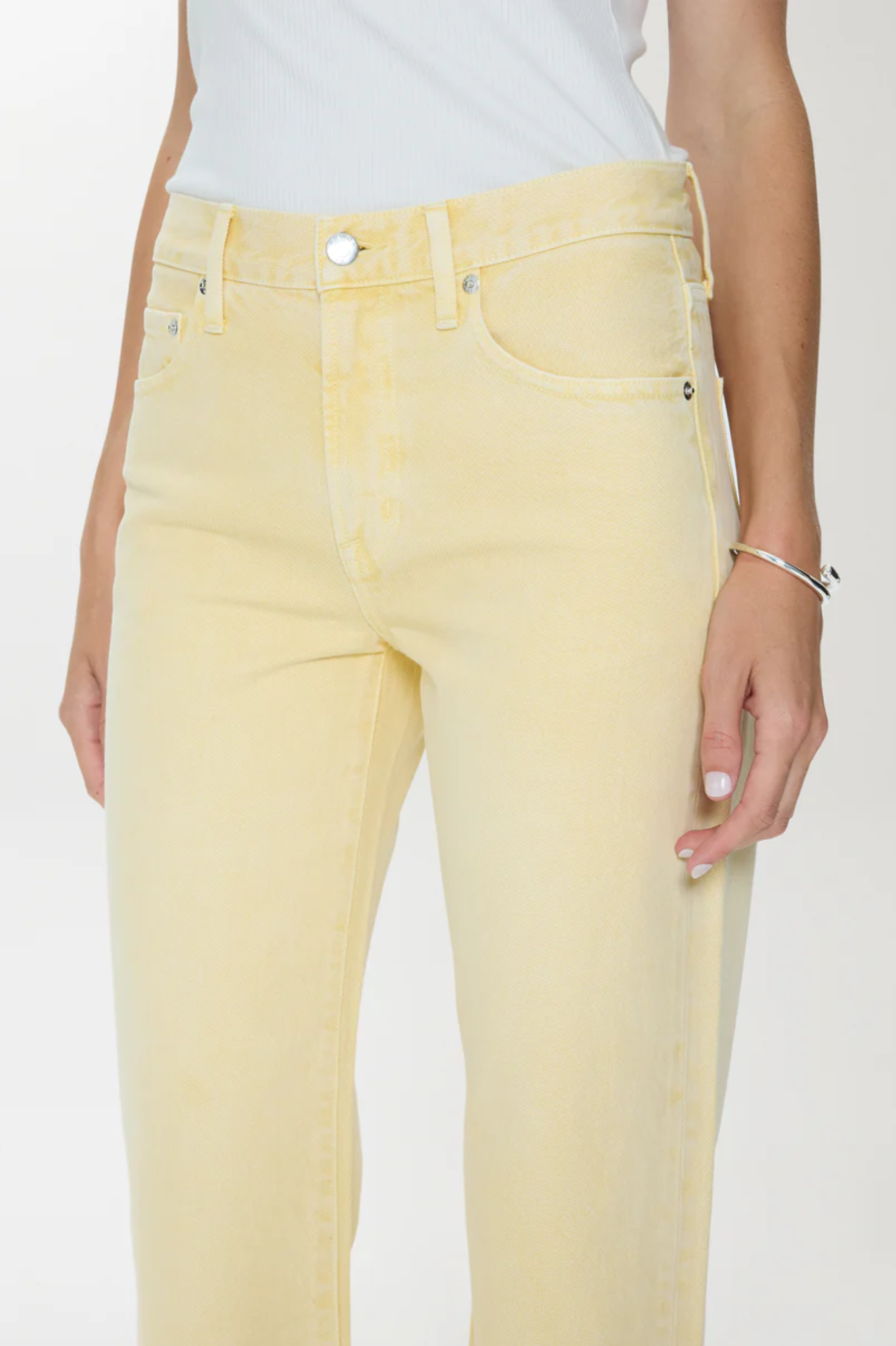 Yellow jeans worn by a person on a white background