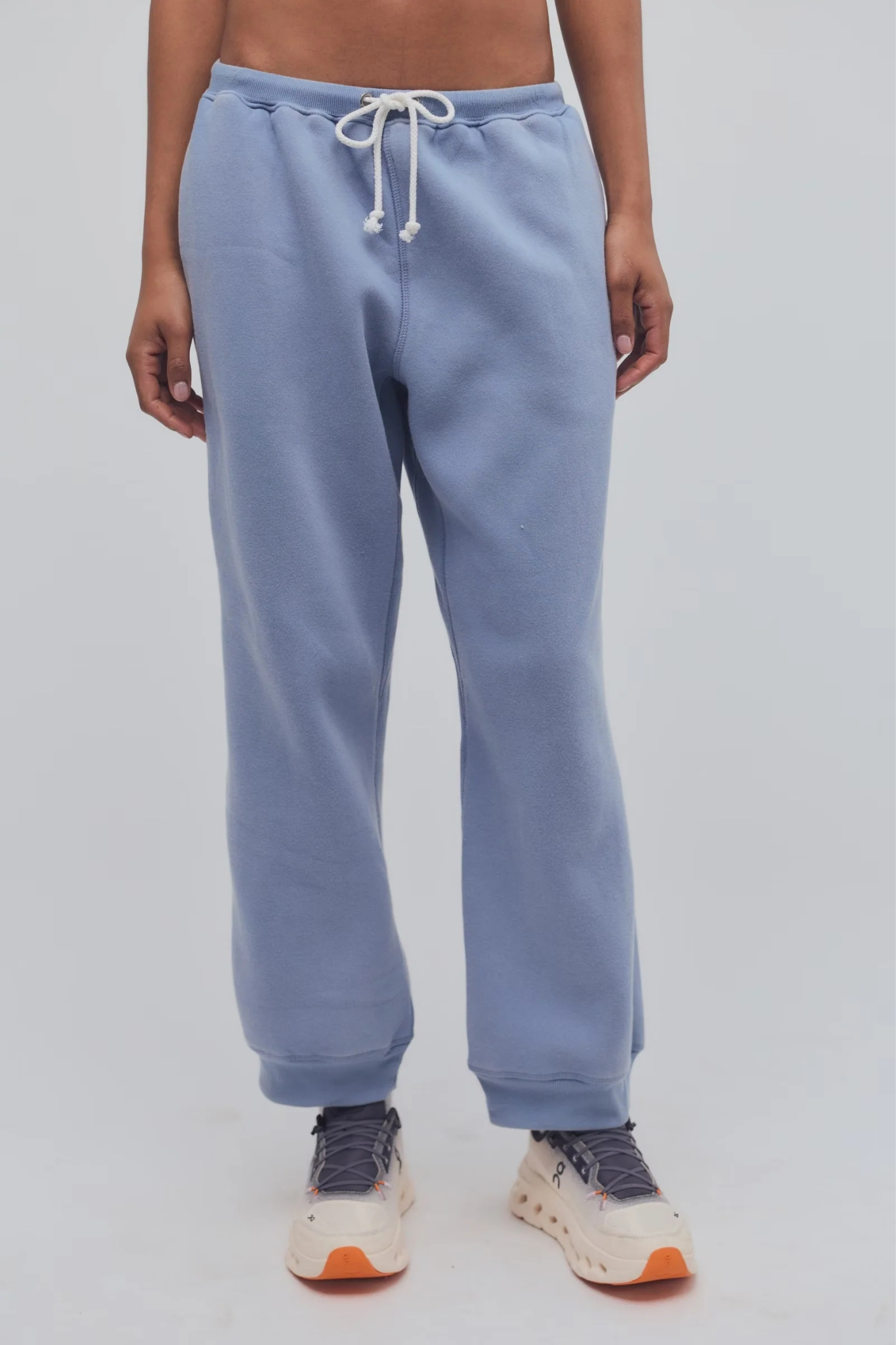 Light blue sweatpants worn by a person on a plain background