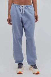 Light blue sweatpants worn by a person on a plain background
