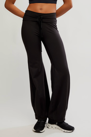 Black wide-leg drawstring sweatpants worn by a model, shown from the waist down against a light gray studio background.