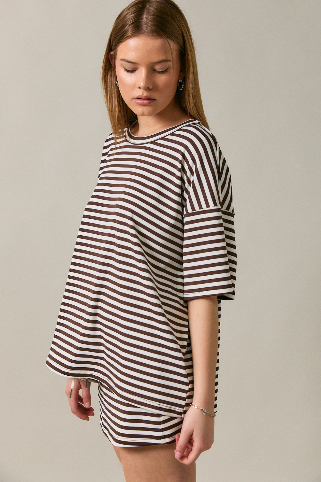 Woman wearing a black and white striped dress against a plain background
