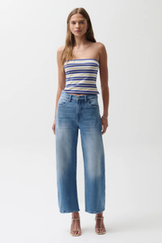 Woman wearing a striped top and blue jeans on a white background