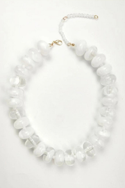 A white beaded necklace made of large, irregular disc-like beads with a gold clasp and extender chain, displayed on a clean white background.