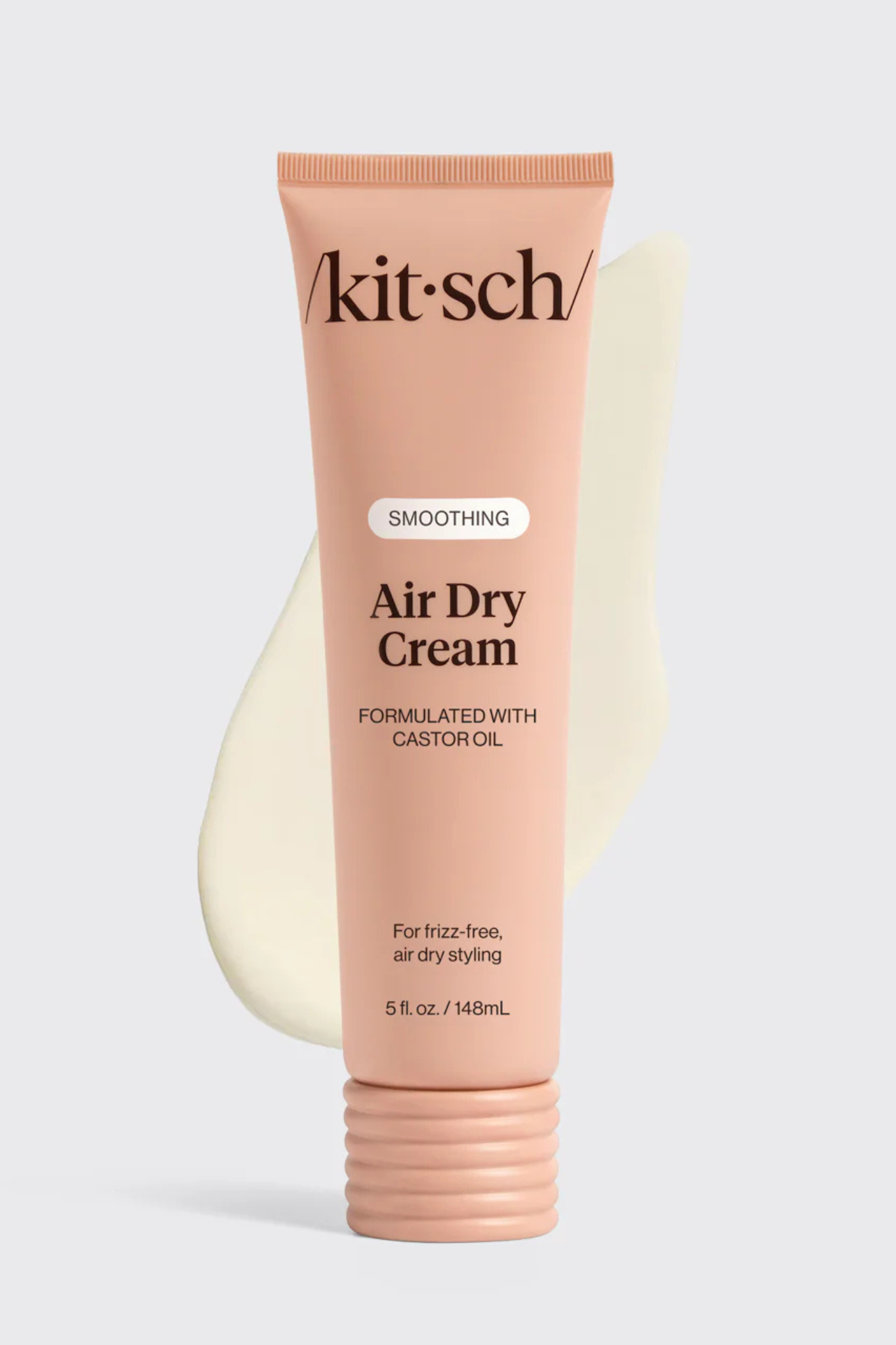 A tube of Akit-Sch smoothing Air Dry Cream in a soft peach-pink color, displayed against a light gray background with a cream-colored smear graphic behind it.