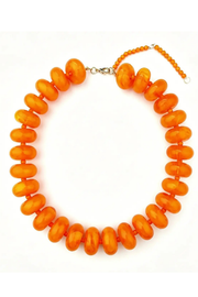 An orange beaded necklace with chunky, rounded disc-shaped beads and a silver-tone clasp, displayed on a clean white background.
