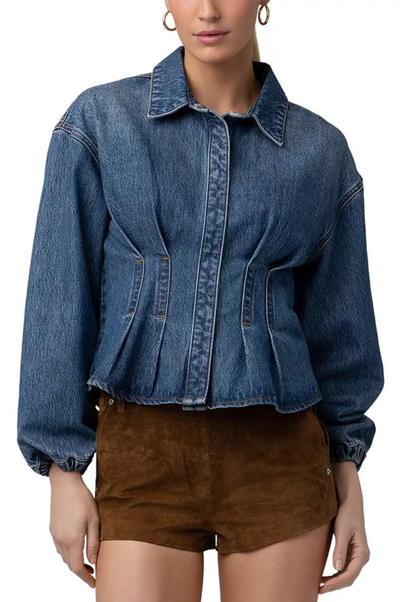 A woman wearing a cropped blue denim jacket with long sleeves and front pockets, paired with brown shorts, shown against a plain white background.
