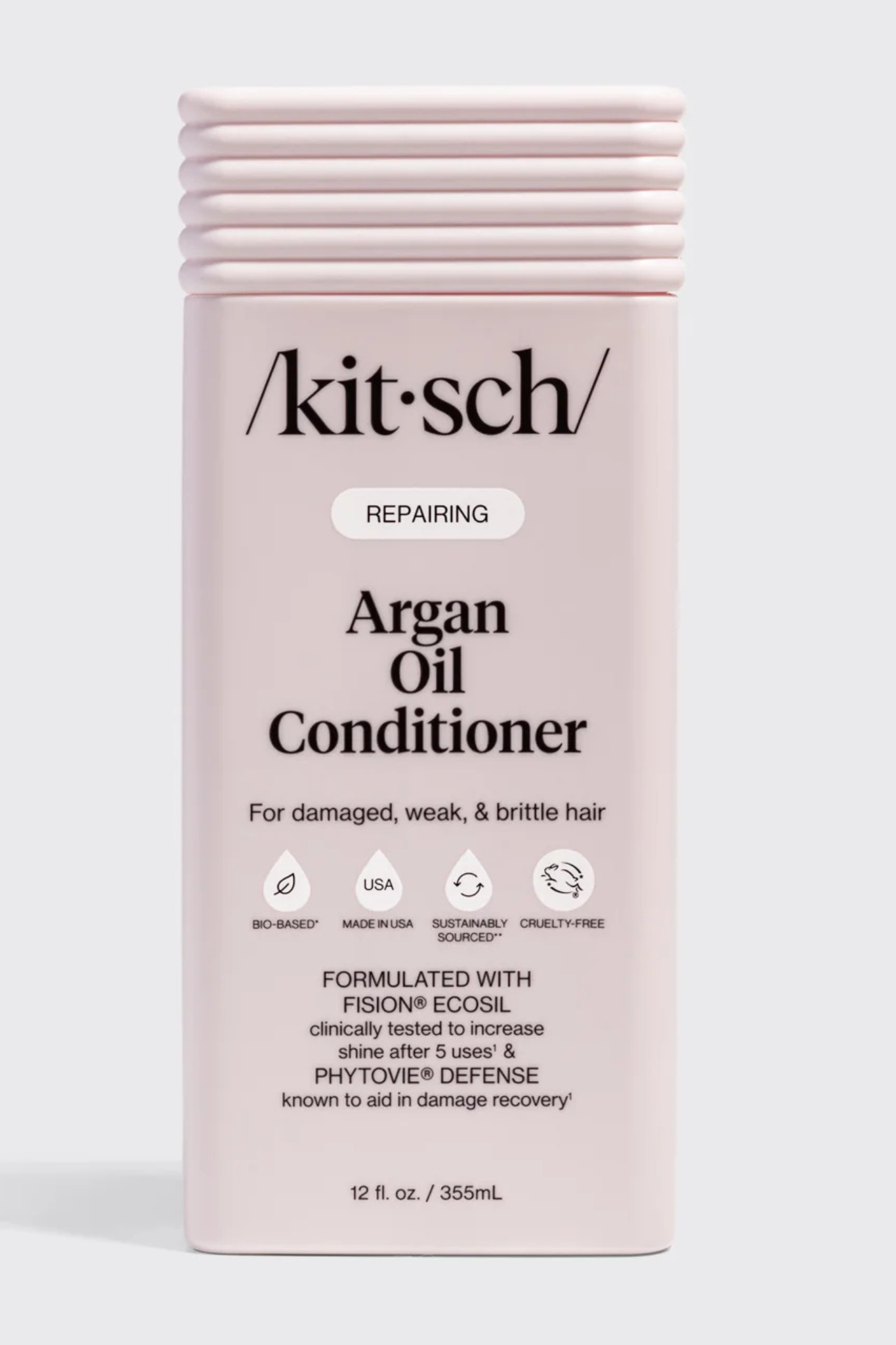 Kitsch Repairing Argan Oil Conditioner in a pale pink rectangular bottle with a ribbed cap, shown on a light gray background.