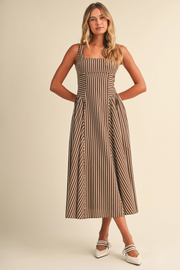 Woman wearing a striped dress against a plain background