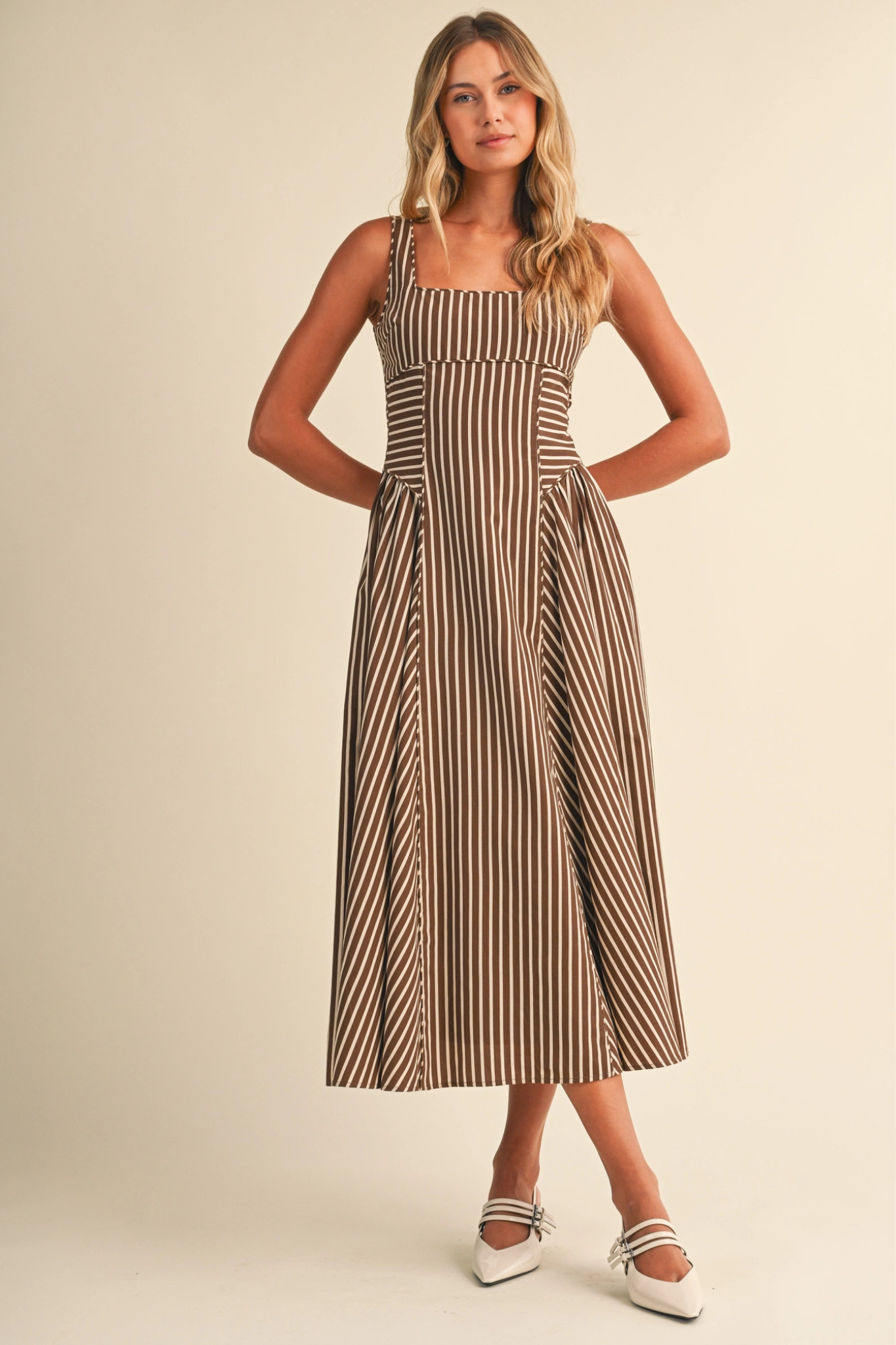 Woman wearing a striped dress against a plain background