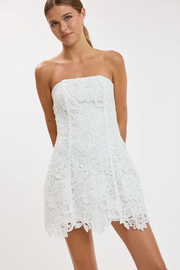 Woman wearing a white strapless lace dress on a white background