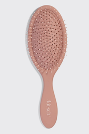 A dusty pink oval hairbrush with a matching handle, featuring the brand name 'kitsch' printed in white on the handle, set against a light gray background.