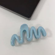 Blue hair clip shaped like a wavy line on a white background