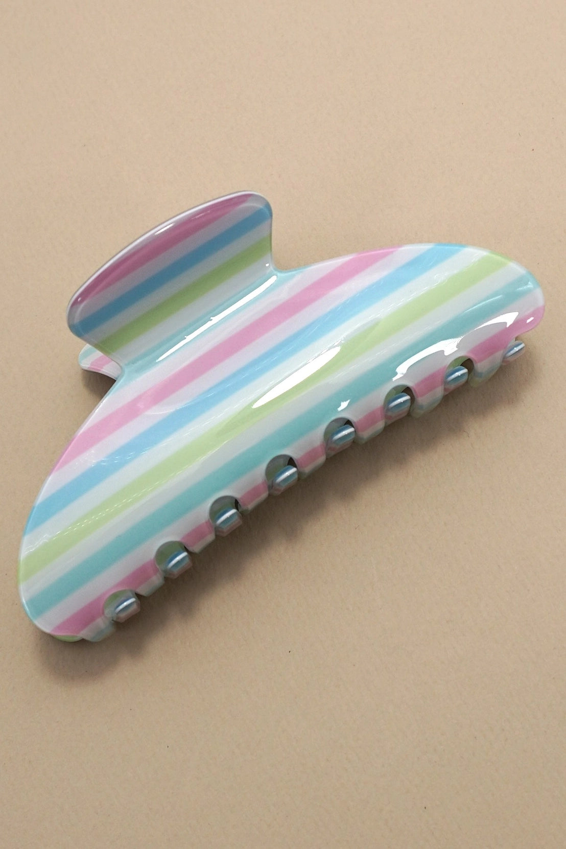 Colorful striped hair clip on a beige background