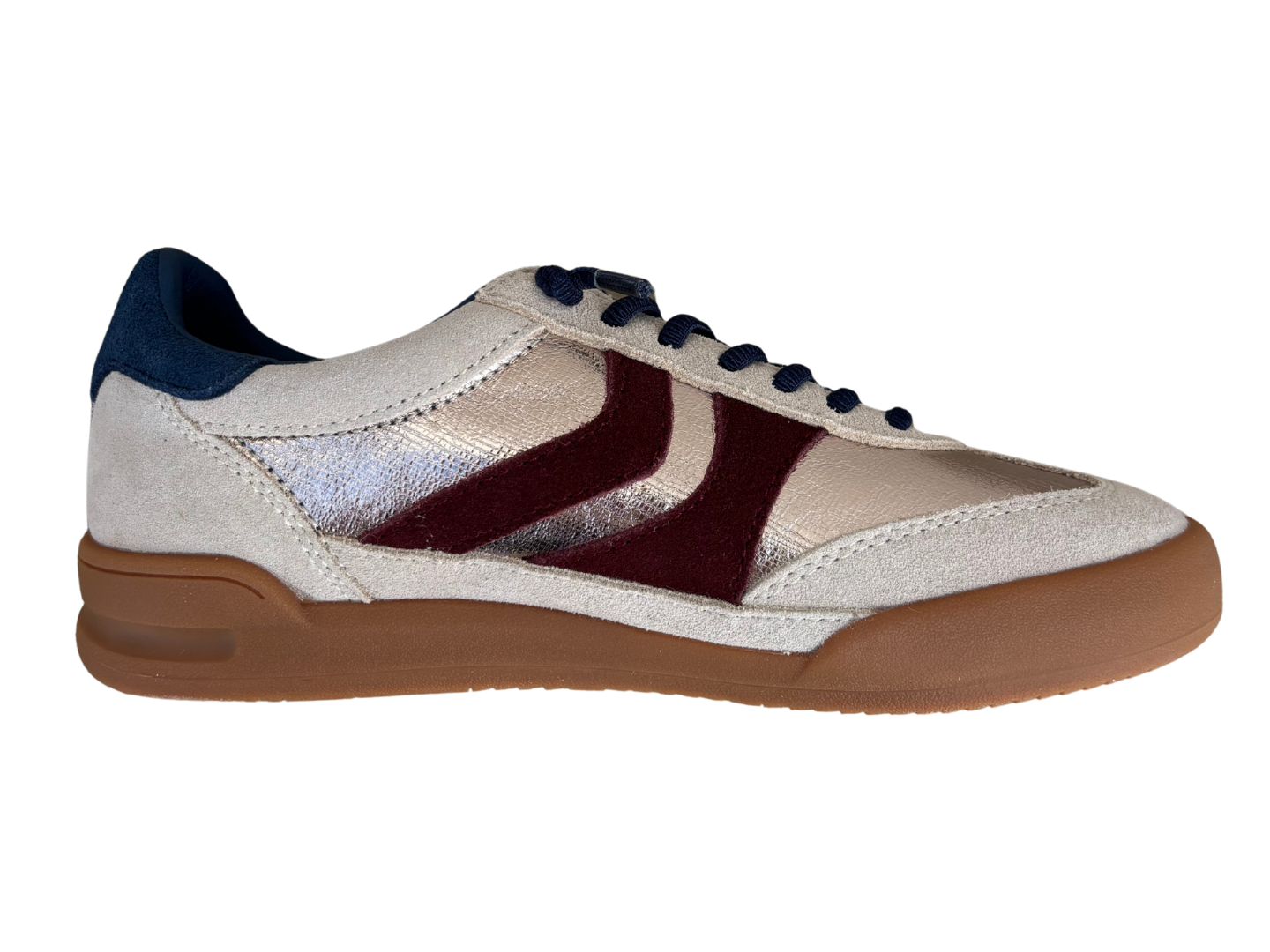 A low-top sneaker with a metallic silver and beige upper, dark burgundy side stripes, navy blue laces and heel tab, and a brown gum sole, shown from a side profile on a white background.
