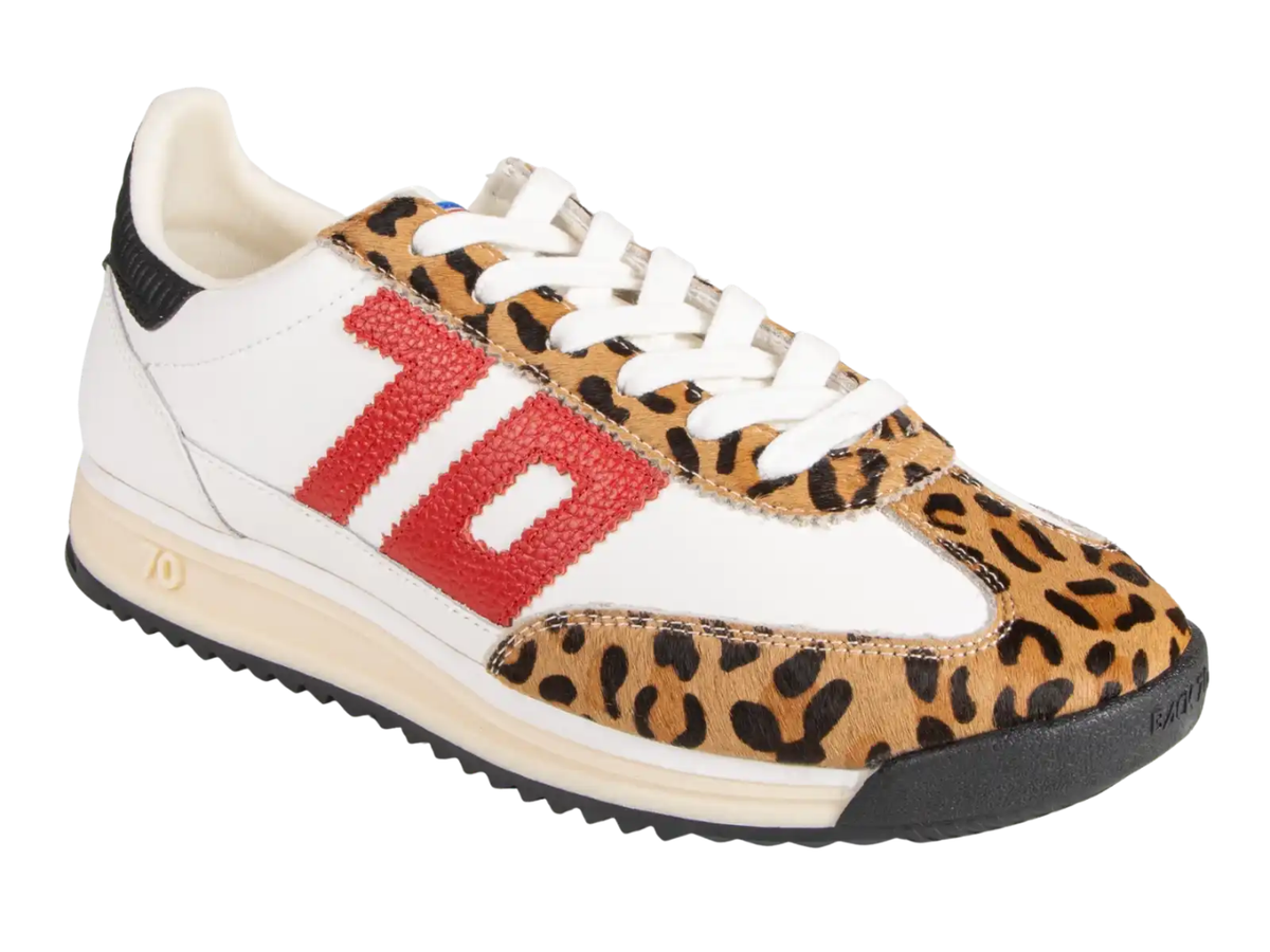 A low-top sneaker featuring a white leather base, tan and black leopard print panels, a large textured red '10' on the side, white laces, and a beige and black sole.
