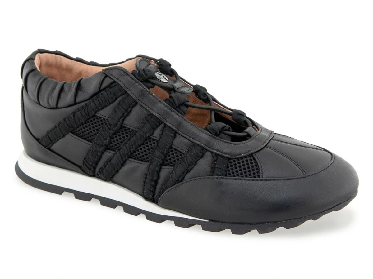 A black low-top sneaker with a mix of smooth leather and mesh panels, featuring a white midsole and a black treaded outsole, shown against a plain white background.