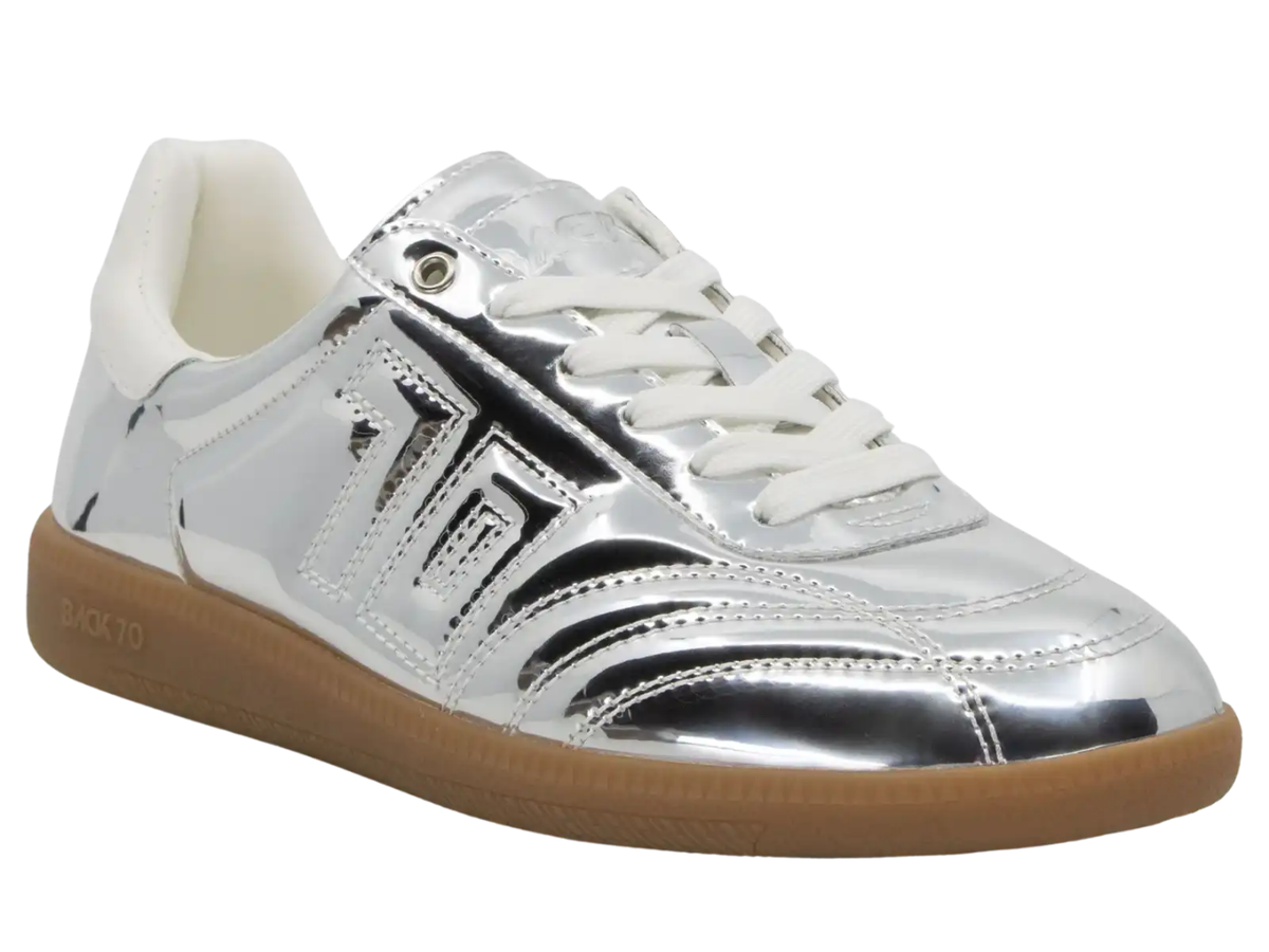 A metallic silver low-top sneaker with white laces, a white collar lining, and a brown gum sole, shown on a plain white background.