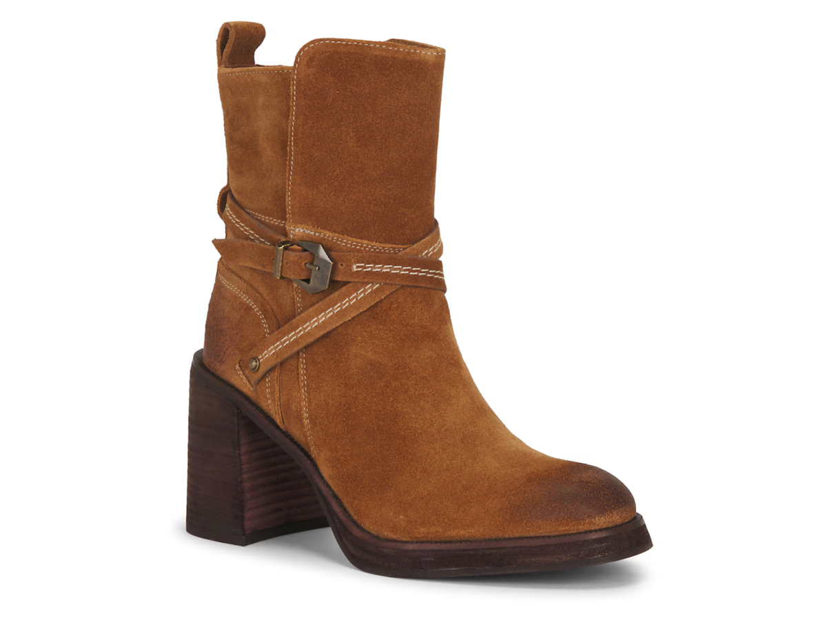 A single brown suede ankle boot with a dark brown block heel, featuring a decorative strap with a silver buckle around the ankle, set against a plain white background.