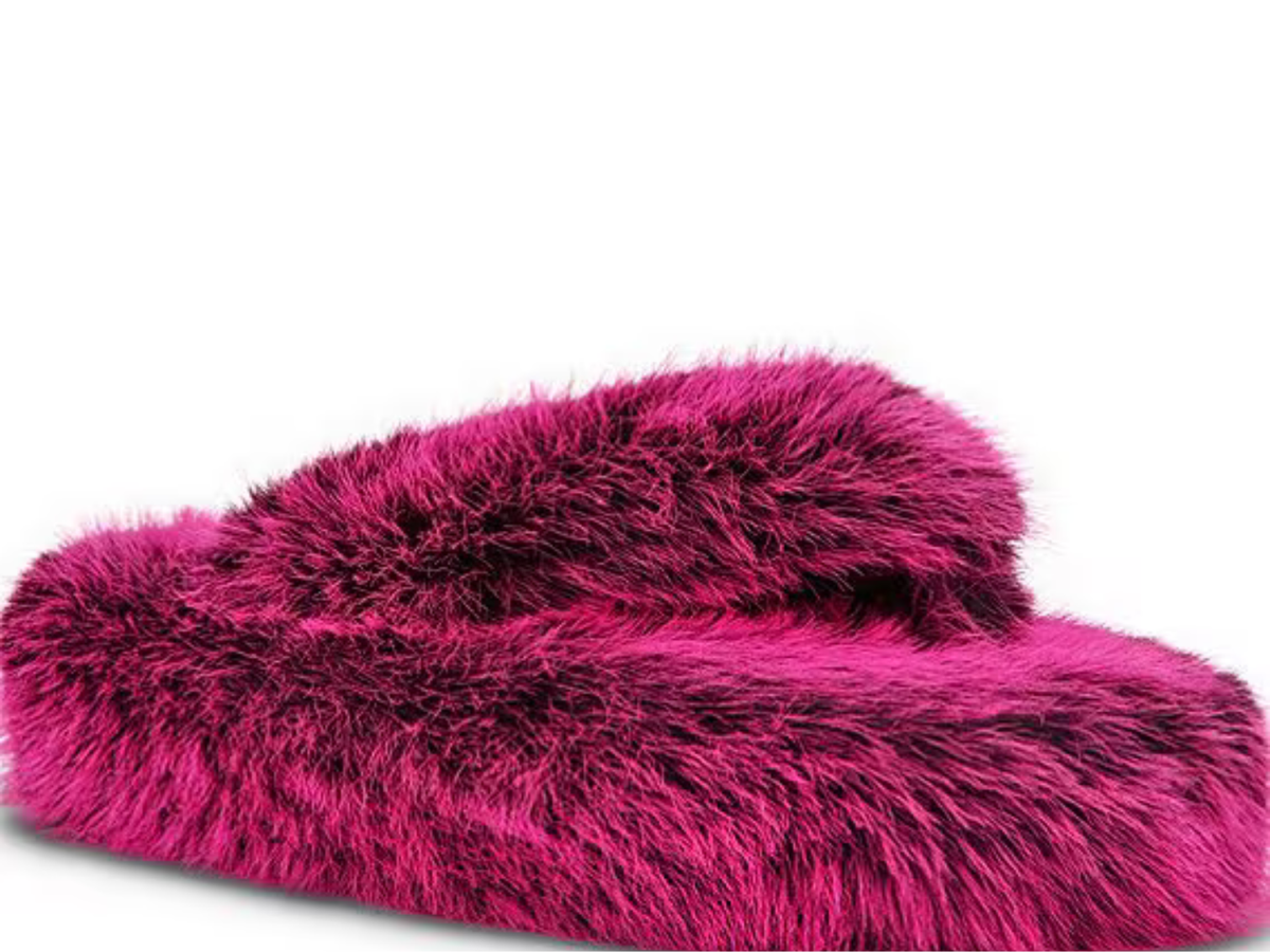 A pair of plush, bright magenta faux fur slippers on a clean white background.