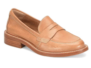 A tan leather penny loafer with a low stacked heel, photographed from a three-quarters angle on a white background.