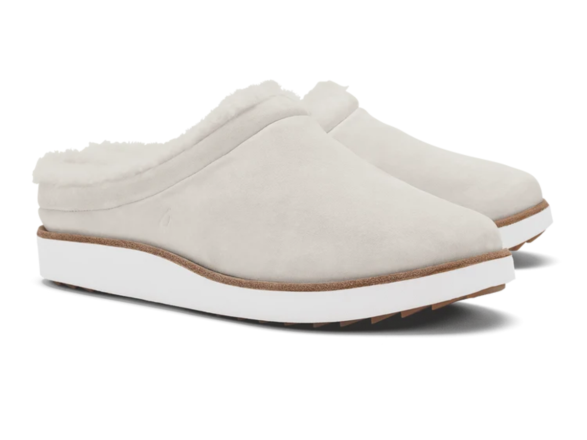 A pair of off-white slip-on clogs with soft white faux-fur lining and thick white platform soles, shown on a clean white background.