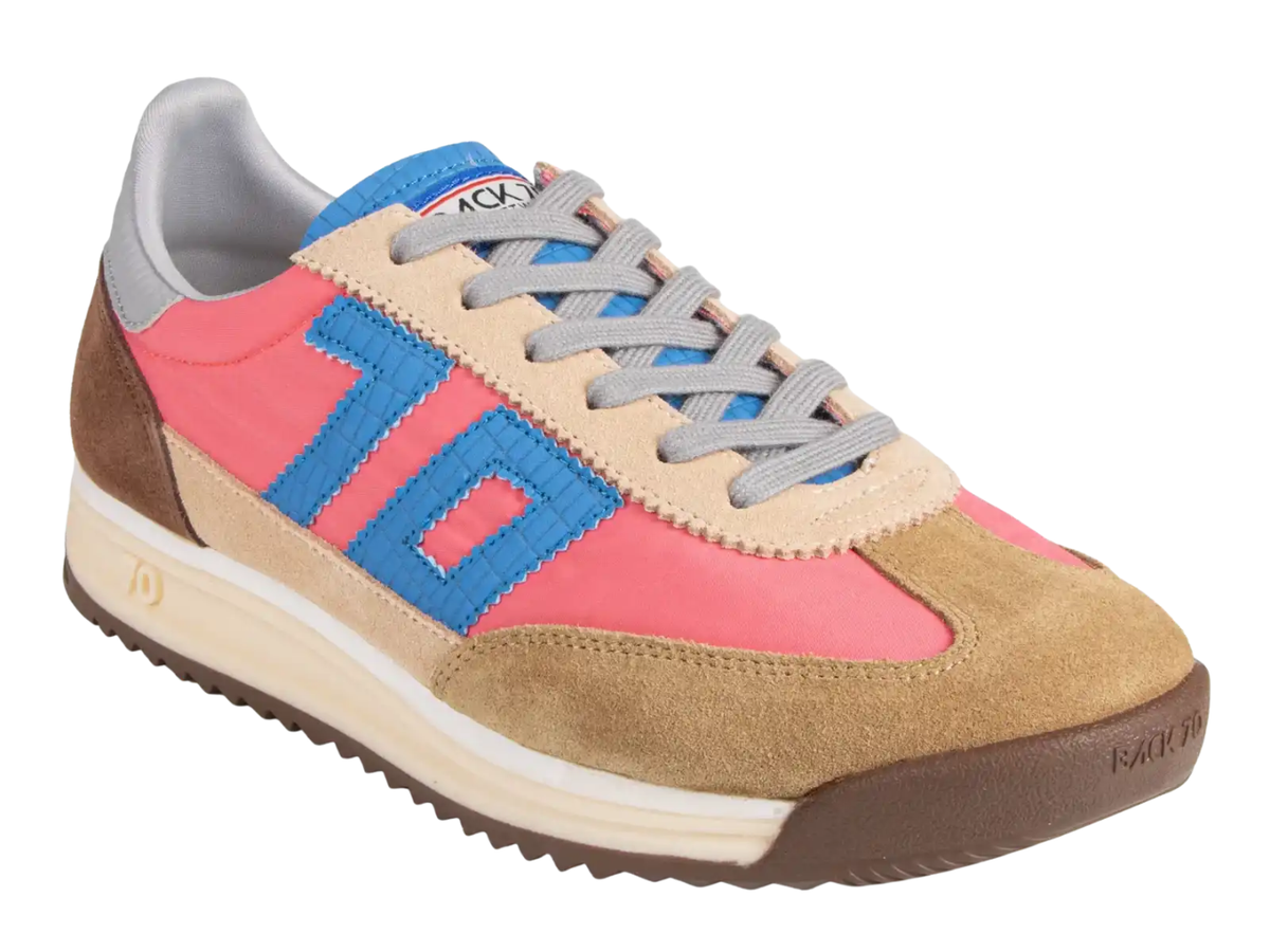 A low-top sneaker by Rochas with a color-blocked design featuring tan suede, pink panels, blue accents, beige overlays, gray laces, and a brown outsole, shown on a plain white background.