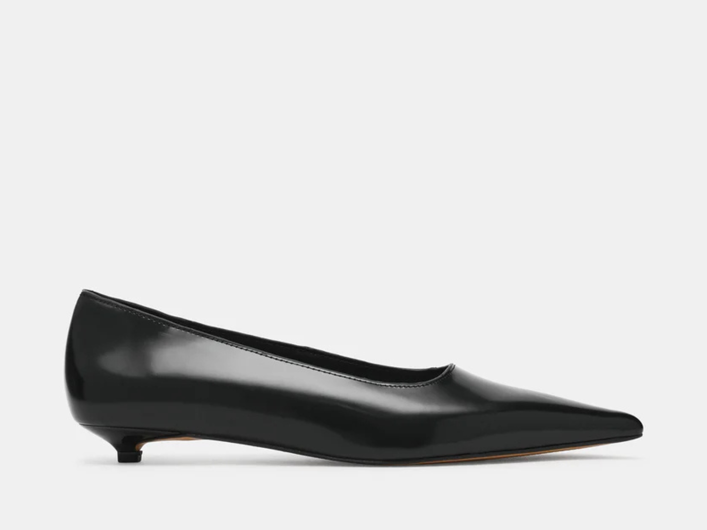 A single black patent leather pointed-toe flat shoe with a kitten heel, shown in a side profile against a light gray background.