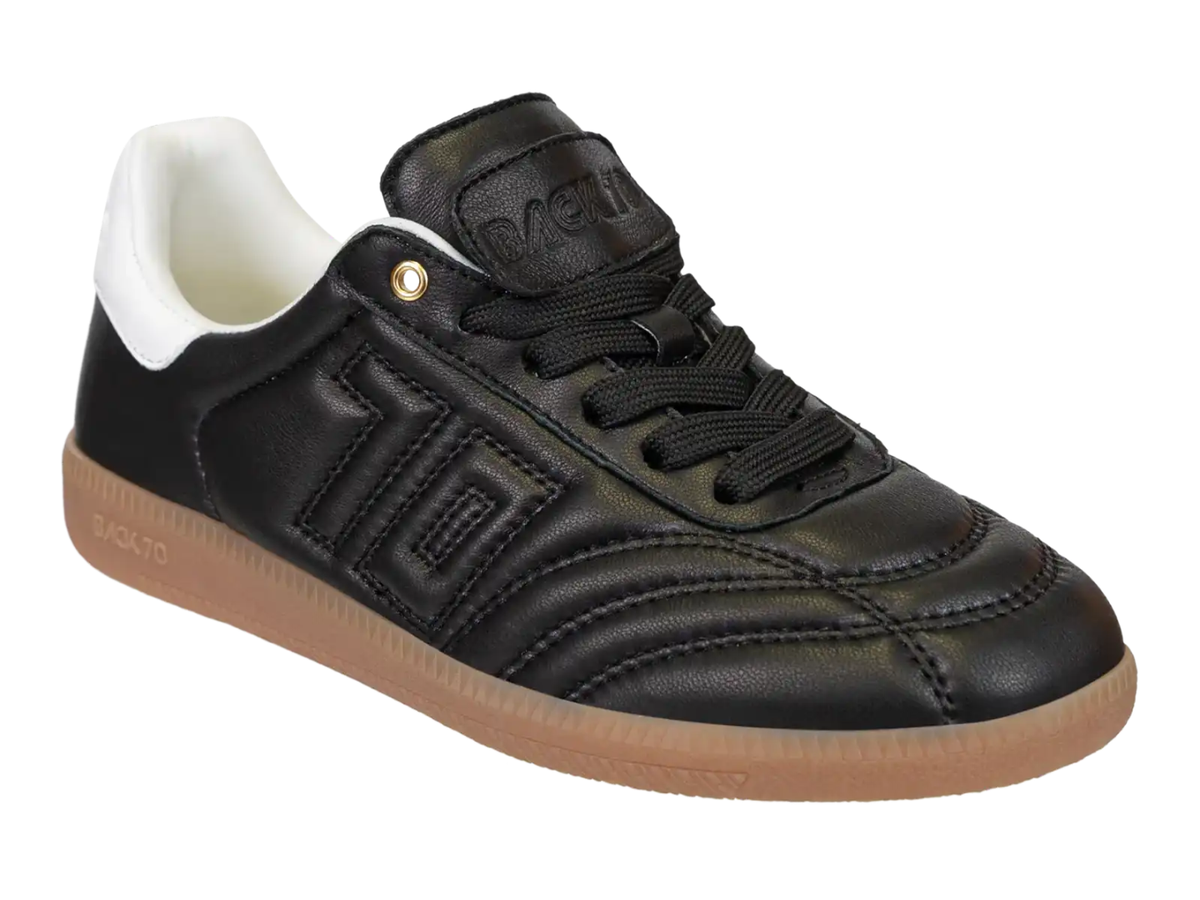 A black leather low-top sneaker with black laces, a white collar lining, and a gum brown sole, shown on a plain white background.