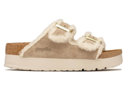 A single Papillio mule slide sandal featuring a beige suede upper, plush cream shearling lining, and gold-tone buckle straps, shown in profile against a white background.