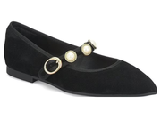 A black suede Mary Jane flat shoe with pointed toe, featuring a black elastic strap adorned with two gold-tone rings and two decorative pearl embellishments, shown on a plain white background.